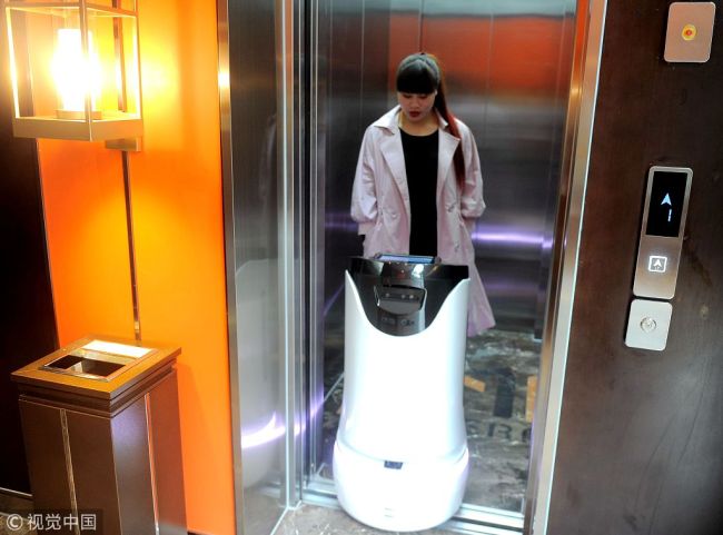 A robot serves a customer at a hi-tech hotel in Chengdu, Sichuan Province on March 20, 2018. [Photo: VCG]