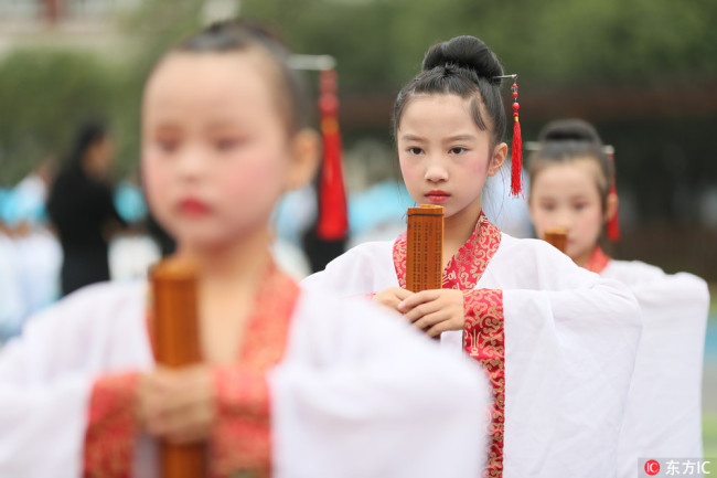 Students dressed in traditional costumes attend a ceremony to mark the 2569th anniversary of Confucius' birth at a primary school in Hengyang city, central China's Hunan province, on Friday, Sept. 28, 2018.
