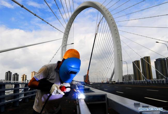 A worker welds(焊接) on the Baisha Bridge in Liuzhou, south China's Guangxi Zhuang Autonomous Region, Sept. 26, 2018.(Xinhua/Li Hanchi)