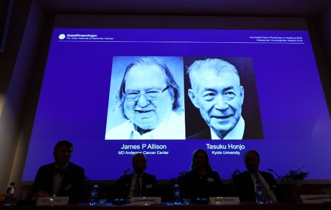 Members of the Nobel Committee for Physiology or Medicine sit in front of a screen displaying James P Allison (L) and Tasuku Honju, the winners of the 2018 Nobel Prize in Physiology or Medicine, during a press conference at the Karolinska Institute in Stockholm, Sweden, on October 1, 2018. [Photo: Jonathan NACKSTRAND / AFP]