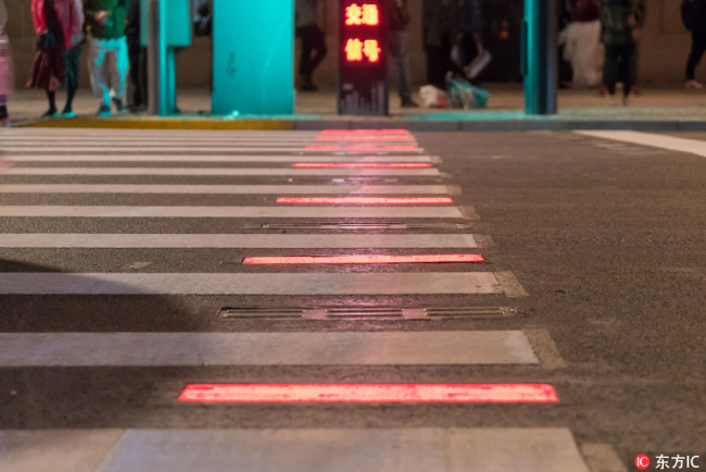 Pedestrians are seen walking on an illuminated sidewalk in Shanghai on October 10, 2018. [Photo: VCG] 