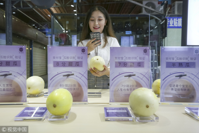 A customer scans a muskmelon with her smartphone to measure its sweetness at a store in Haikou, the capital of south China's Hainan Province, on October 10, 2018. [Photo: VCG]