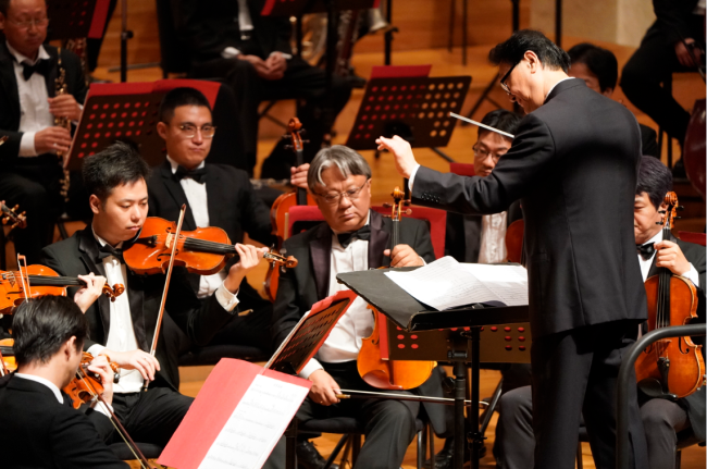 One of China's most influential conductors, Tan Lihua (right), conducts the Beijing Symphony Orchestra at a concert "Embracing the New Era" on October 15, 2018. [Photo provided to China Plus]