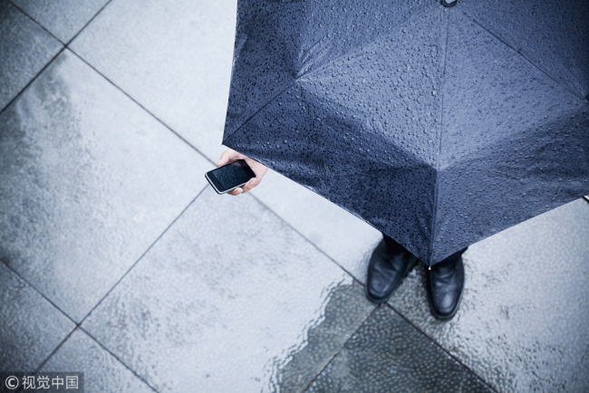 An iPhone being used in the rain. [Photo:VCG]