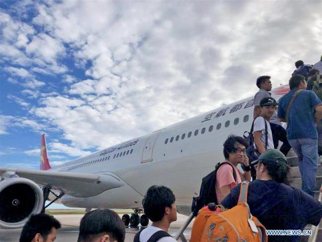 Chinese tourists get on board to fly back home in Saipan, the Commonwealth of the Northern Mariana Islands (CNMI), Oct. 28, 2018. Some 1,500 Chinese tourists trapped in Saipan by Super Typhoon Yutu started to fly back home on Sunday. [Photo: Xinhua]