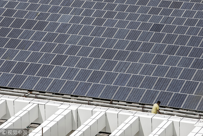 A worker walks past a rooftop solar farm at the BYD Co. headquarters in Shenzhen, China, September 21, 2017. [File photo:VCG]