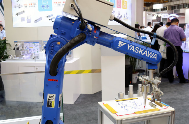 A robot arm in a writing demonstration at SMC China's booth at the 4th World Robot Conference at the Etrong International Conference and Exhibition Center in Beijing on Wednesday, August 15, 2018. [Photo: China Plus]