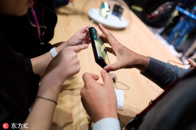 Customers try out the large-screen foldable devices launched by Royole Corp, a manufacturer of flexible displays and smart devices, during a press conference in Beijng, China, October 31.[Photo: IC]