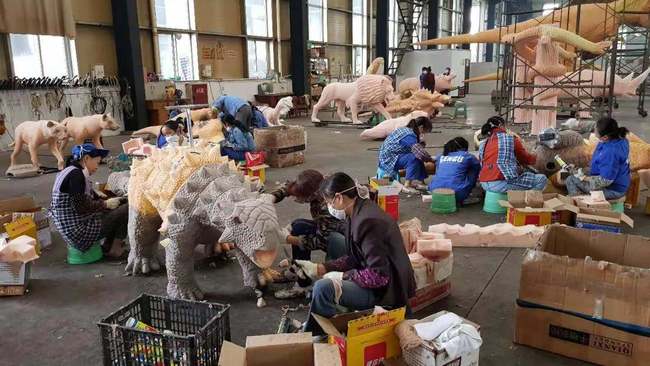 Employees at Gengu Dinosaurs covering replicas with silicone rubber and silk stockings.[Photo: CGTN]