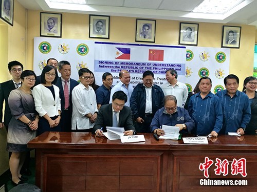 Jin Yuan(left), the economic and commercial counselor of the Chinese embassy in the Philippines and assistant minister(right)of the Philippine Department of Health sign minutes of talks on feasibility of construction of a Chinese-financed drug rehabilitation center at the Department of Health in the Philippines on March 13, 2017. [File Photo: Chinanews.com]