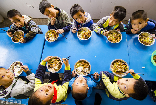 Primary school students eating "free lunch" provided by the school feeding project, seen here on November 7, 2018, in Liuzhou, Guangxi Province. [Photo:VCG]