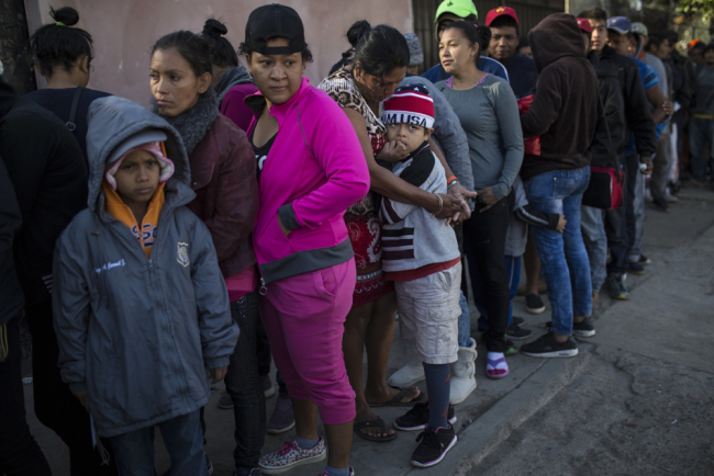 Central American migrants wait in line for a donated breakfast at a temporary shelter in Tijuana, Mexico, early Saturday morning, Nov. 17, 2018. [Photo: AP/Rodrigo Abd]