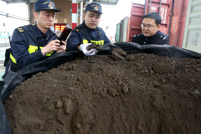 Chinese customs officers check illegal trash imports they seized during a crackdown on trash smuggling in Qingdao city, east China's Shandong province, 22 May 2018. [Photo: IC]
