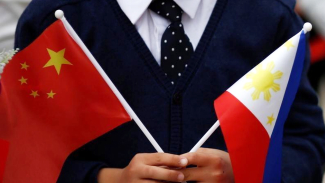 A child holds national flags of China and the Philippines before President of the Philippines Rodrigo Duterte and China's President Xi Jinping attend a welcoming ceremony at the Great Hall of the People in Beijing on October 20, 2016. [File Photo: VCG]