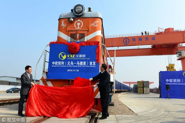 Officials unveil the first YXE international container train travelling between Yiwu and Madrid during an inaugural ceremony at a container terminal in Yiwu city, east China's Zhejiang Province, 18 November 2014. [Photo: VCG]