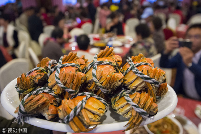 Visitors eat Mitten Crabs in Nantong, Jiangsu Province, November 2, 2018. Jiangsu is famous for its Yangcheng Lake Chinese Mitten Crabs. [Photo: VCG]