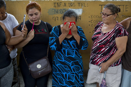 In this Oct. 31, 2018 photo, Haydee Esperanza Posadas, covers her face with a small red towel to wipe away tears and sweat, during the burial of her son Wilmer Gerardo Nunez at a cemetery in San Pedro Sula, Honduras. Eight years and three months after the last hug from her son Wilmer, Posadas says she feels peace for the first time, although she still wants justice. [File photo: AP]