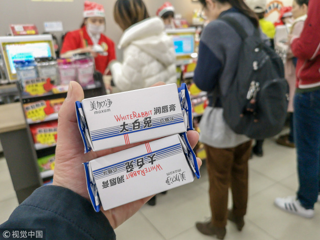 Customers buy White Rabbit Creamy Candy-flavored lip balm at a supermarket in Shanghai on Friday, December 7, 2018. [Photo: VCG]