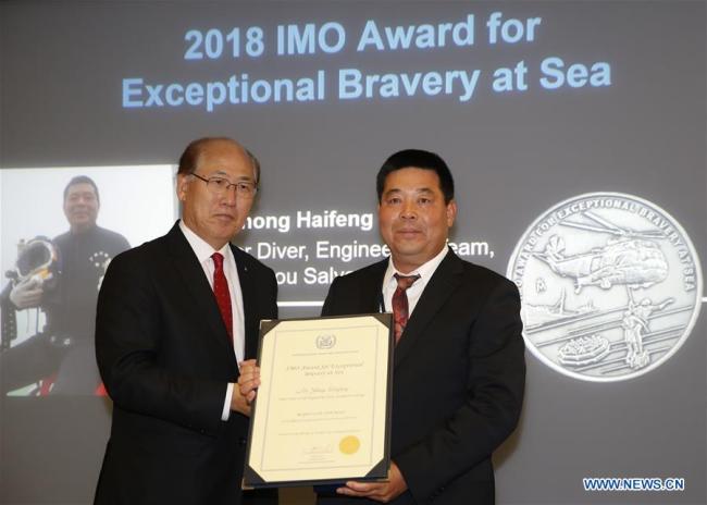 Chinese diver Zhong Haifeng (R) is presented the 2018 International Maritime Organization (IMO) Award for Exceptional Bravery At Sea by IMO Secretary-General Kitack Lim in London, Britain, Dec. 6, 2018. Zhong is a rescue diver from Guangzhou Salvage Bureau of Chinese Ministry of Transport. He made a series of underwater dives to rescue three people, when a cargo ship sank after colliding with another in China's Guangzhou Port in last November. A Panel of Judges agreed that Zhong demonstrated "truly exceptional bravery and human spirit" during the rescue "by personally exerting tireless efforts under highly dangerous circumstances". [Photo: Xinhua/Han Yan]