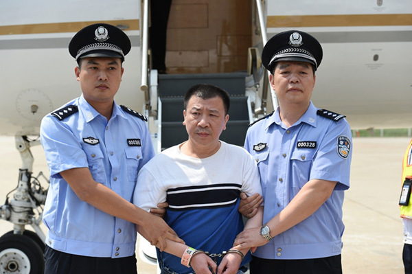 Yang Jinjun, who is accused of bribery and embezzlement,  in handcuffs arriving in China. [Photo: ccdi.gov.cn]