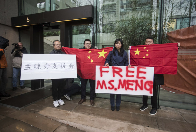 Supporters hold signs and Chinese flags outside British Columbia Supreme Court during the third day of a bail hearing for Meng Wanzhou, the chief financial officer of Huawei Technologies, in Vancouver, on Tuesday December 11, 2018. [Photo: IC]