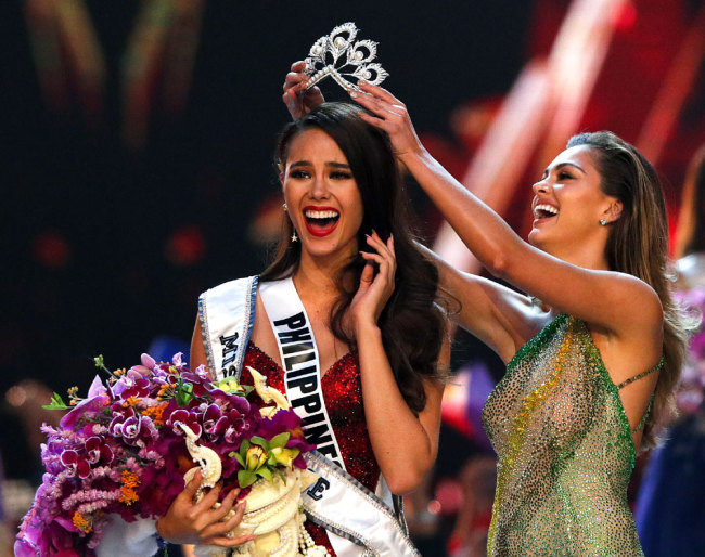 The new Miss Universe 2018 Catriona Gray (L) of the Philippines jubilates as she is crowned by Miss Universe 2017 Demi-Leigh Nel-Peters (R) of South Africa during the Miss Universe 2018 beauty pageant at Impact Arena in Bangkok, Thailand, 17 December 2018. [Photo: IC]