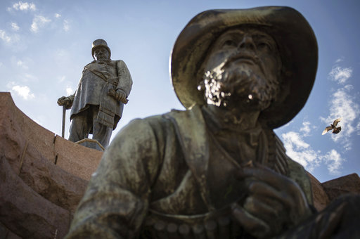A statue of the late Paul Kruger, top, in Church Square, Pretoria, South Africa, looms over one of four statues of men with rifles, Thursday Dec. 13, 2018. Nearly 25-years after the end of white minority rule, the statue of Paul Kruger stands testament to South Africa's harsh past, but also stirs deep divisions about whether the statue should remain or be scrapped. [Photo: AP]