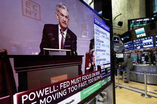 The speech of Federal Reserve Chairman Jerome Powell, to the Economic Club of New York, appears on a television screen on the floor of the New York Stock Exchange, Wednesday, Nov. 28, 2018. Powell cast a bright picture of the U.S. economy Wednesday and appeared to suggest that the Fed might consider a pause in its interest rate hikes next year to assess the impact of its credit tightening.[Photo:AP]