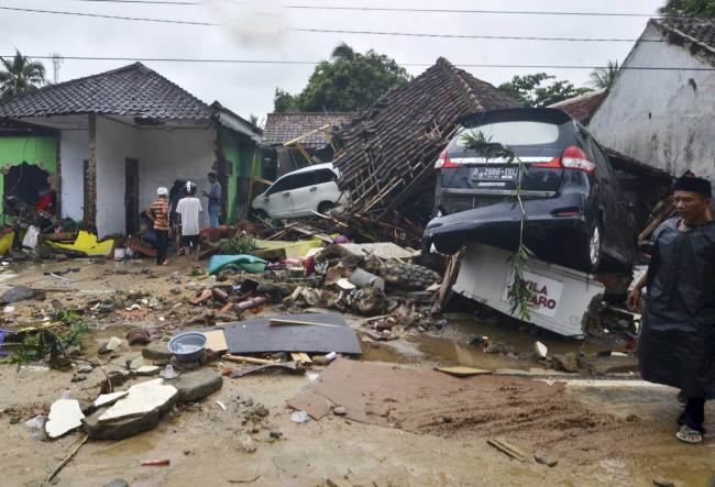 People inspect the damage at a tsunami-ravaged neighborhood in Carita, Indonesia, Sunday, Dec. 23, 2018. [Photo: AP] 