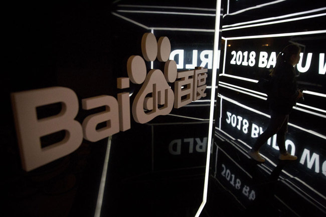 An attendee walks past a display at the 2018 Baidu World conference in Beijing, Thursday, Nov. 1, 2018. Chinese technology company Baidu announced on Thursday that it is partnering with Swedish carmaker Volvo to develop electric cars with autonomous-driving capabilities.[Photo:AP]