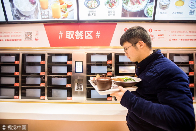 A customer passes the self-service food cabinets at an unmanned restaurant in Hangzhou, Zhejiang Province on January 30, 2018. [File photo: VCG]
