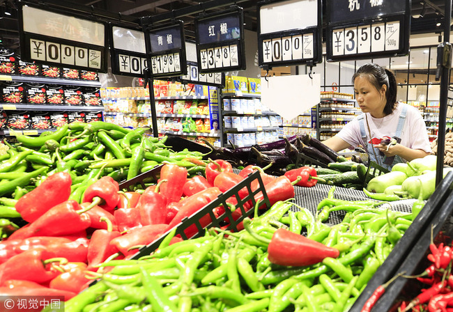 A consumer selects vegetables in a supermarket in Nanchang, Jiangxi Province. [Photo: VCG]