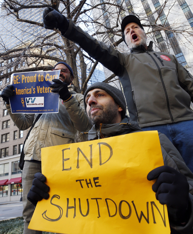 Government workers and their supporters hold signs during a protest in Boston, Friday, Jan.11, 2019. The workers rallied with Democratic U.S. Sen. Ed Markey and other supporters to urge that President Donald Trump put an end to the shutdown so they can get back to work. [Photo: AP/Michael Dwyer]