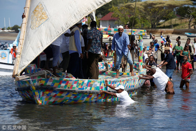 People push Flipflopi, the first dhow boat made entirely of recycled plastic into the water, as it takes its first voyage sail, after the launch ceremony on the island of Lamu, Kenya, September 15, 2018.[Photo via IC/Baz Ratner]