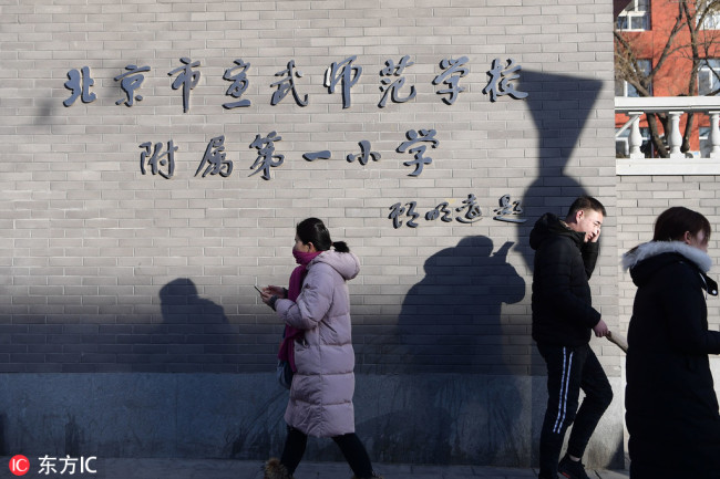 Pedestrians walk past Beijing No.1 Affiliated Elementary School of Xuanwu Normal School after a worker attacked a group of pupils with a hammer at the school in Beijing, January 8, 2019. [Photo: IC]