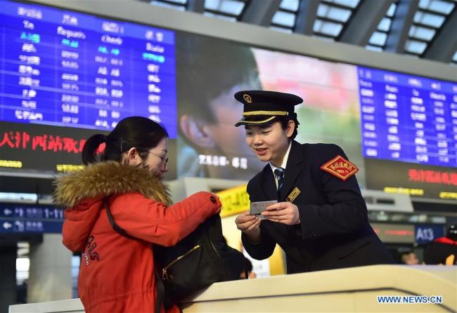 A passenger consults(咨询 zīxún) a staff member(工作人员 gōngzuò rényuán) at Tianjin West Railway Station on Jan 20, 2019. [Photo/Xinhua]