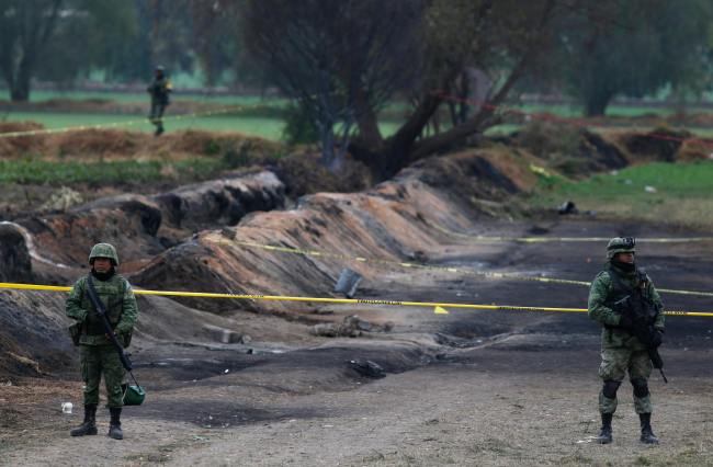 Soldiers guard the site where a gas pipeline exploded two days prior, in the village of Tlahuelilpan, Mexico, Sunday Jan. 20, 2019. [Photo: AP/Claudio Cruz]