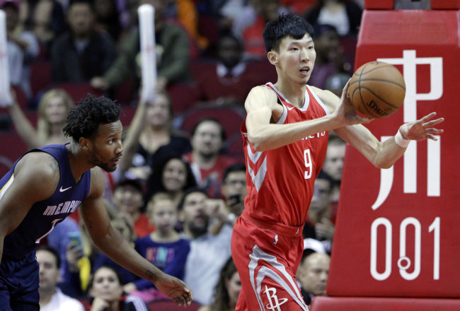 Houston Rockets forward Zhou Qi (9) passes the ball in front of Memphis Grizzlies forward Jarell Martin during the second half of an NBA basketball game Saturday, Nov. 11, 2017, in Houston. [File Photo: AP/Michael Wyke]