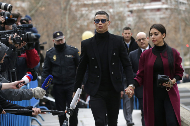Cristiano Ronaldo arrives at the court in Madrid on Tuesday, Jan. 22, 2019. Cristiano Ronaldo is expected to plead guilty to tax fraud. The Juventus forward arrived in a black van, walked up some stairs leading to the court house and stopped to sign an autograph. The charges stem from his days at Real Madrid. [Photo: AP]