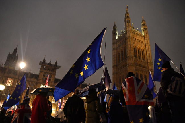 Anti-Brexit activists hold up European Union flags as they demonstrate outside of the Houses of Parliament in London on January 29, 2019.[Photo: AFP/Ben STANSALL]