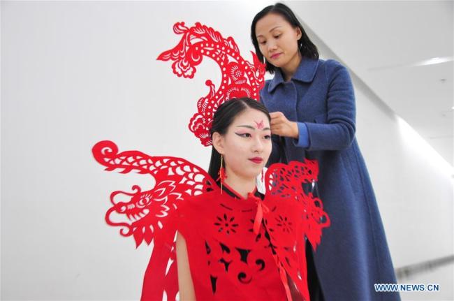 “剪纸”服饰迎新春 Craftswoman makes papercutting works of cheongsam to greet Spring Festival