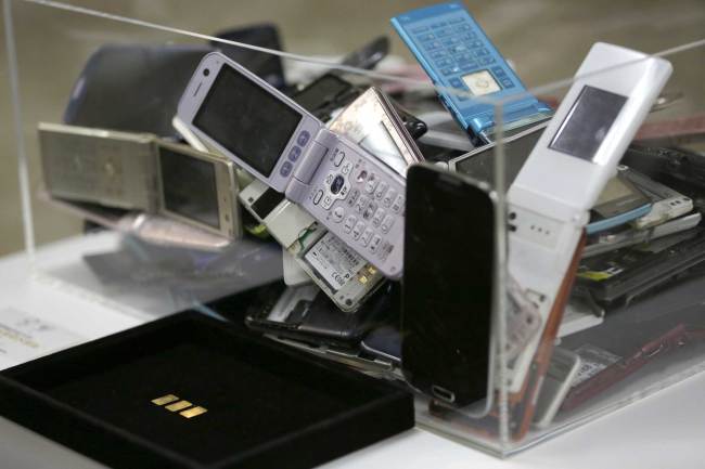 Gold tablets of 3 grams, left, which is able to be recycled from 100 mobile phones, are shown as example in Tokyo on April 1, 2017. [File photo: AP]