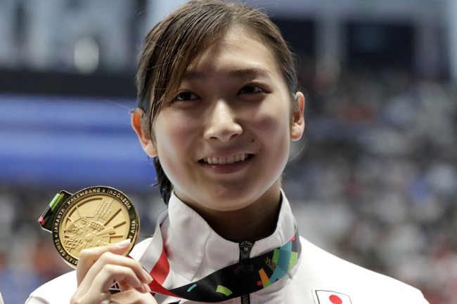 Japan's Rikako Ikee hold sup her gold medal after winning the women's 50m freestyle final during the swimming competition at the 18th Asian Games in Jakarta, Indonesia, Friday, Aug. 24, 2018. [Photo: AP]