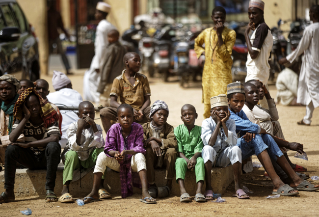 Young Muslim boys wait for traditional Friday prayers to begin at a mosque near to the Emir's palace a day prior to the start of the elections, in Kano, northern Nigeria, Feb. 15, 2019. [Photo: AP/Ben Curtis]