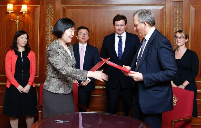 Deputy Governor of the People's Bank of China, Hu Xiaolian (foreground center left), and Deputy Governor of the Bank of England John Cunliffe (center right), prepare to exchange signed MOU on renminbi clearing and settlement in London on Monday, March 31, 2014. This decision further strengthens London's position as the Western center of renminbi trading. [File photo: AP/Olivia Harris, Pool]