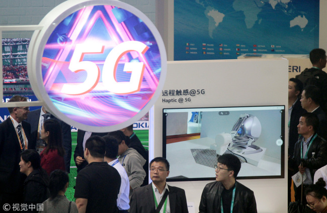 Visitors to a 5G technology exhibition stand at the China International Import Expo in Shanghai on November 7, 2018. [Photo: VCG]