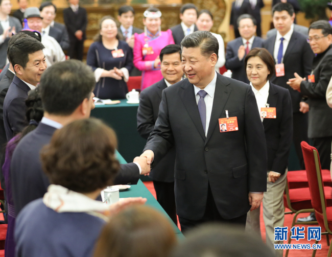 Chinese President Xi Jinping shakes hands with his fellow deputies from the Inner Mongolia Autonomous Region at the second session of the 13th National People's Congress in Beijing, March 5, 2019. [Photo: Xinhua]