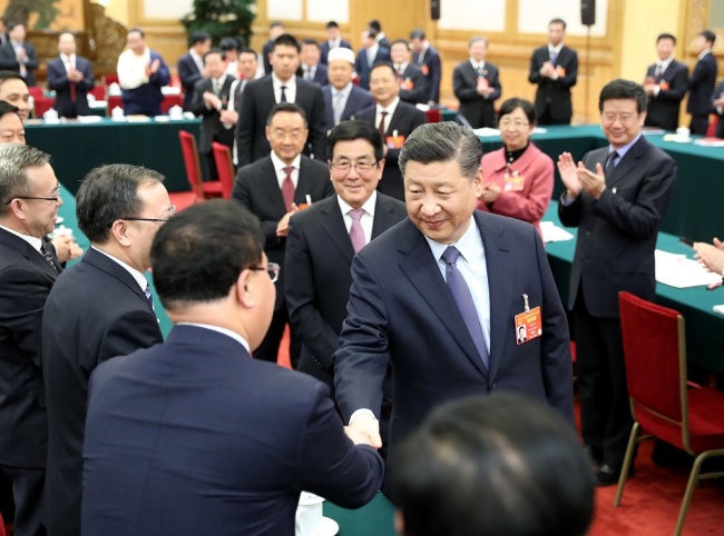 Chinese President Xi Jinping shakes hands with a deputy from Gansu Province at the annual session of the NPC in Beijing, March 7, 2019. [Photo: Xinhua]