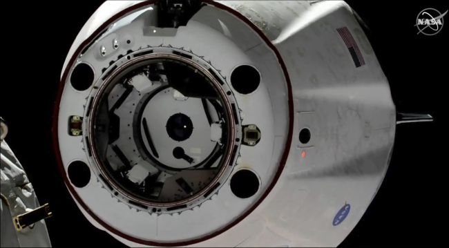 In this image taken from NASA Television, SpaceX's swanky new crew capsule undocks from the International Space Station, left, Friday, March 8, 2019. The capsule undocked and is headed toward an old-fashioned splashdown. The Dragon capsule pulled away from the orbiting lab early Friday, a test dummy named Ripley its lone occupant. [Photo: NASA TV via AP]