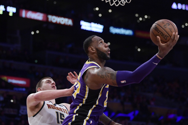 Los Angeles Lakers forward LeBron James, right, shoots as Denver Nuggets center Nikola Jokic defends during the second half of an NBA basketball game Wednesday, March 6, 2019, in Los Angeles. The Nuggets won 115-99. [Photo: AP]